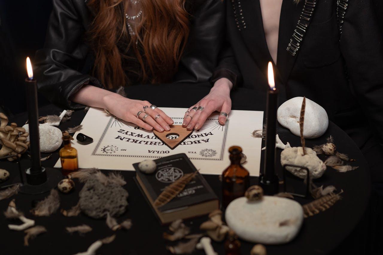 A mysterious scene with people using a Ouija board surrounded by candles and mystical items.